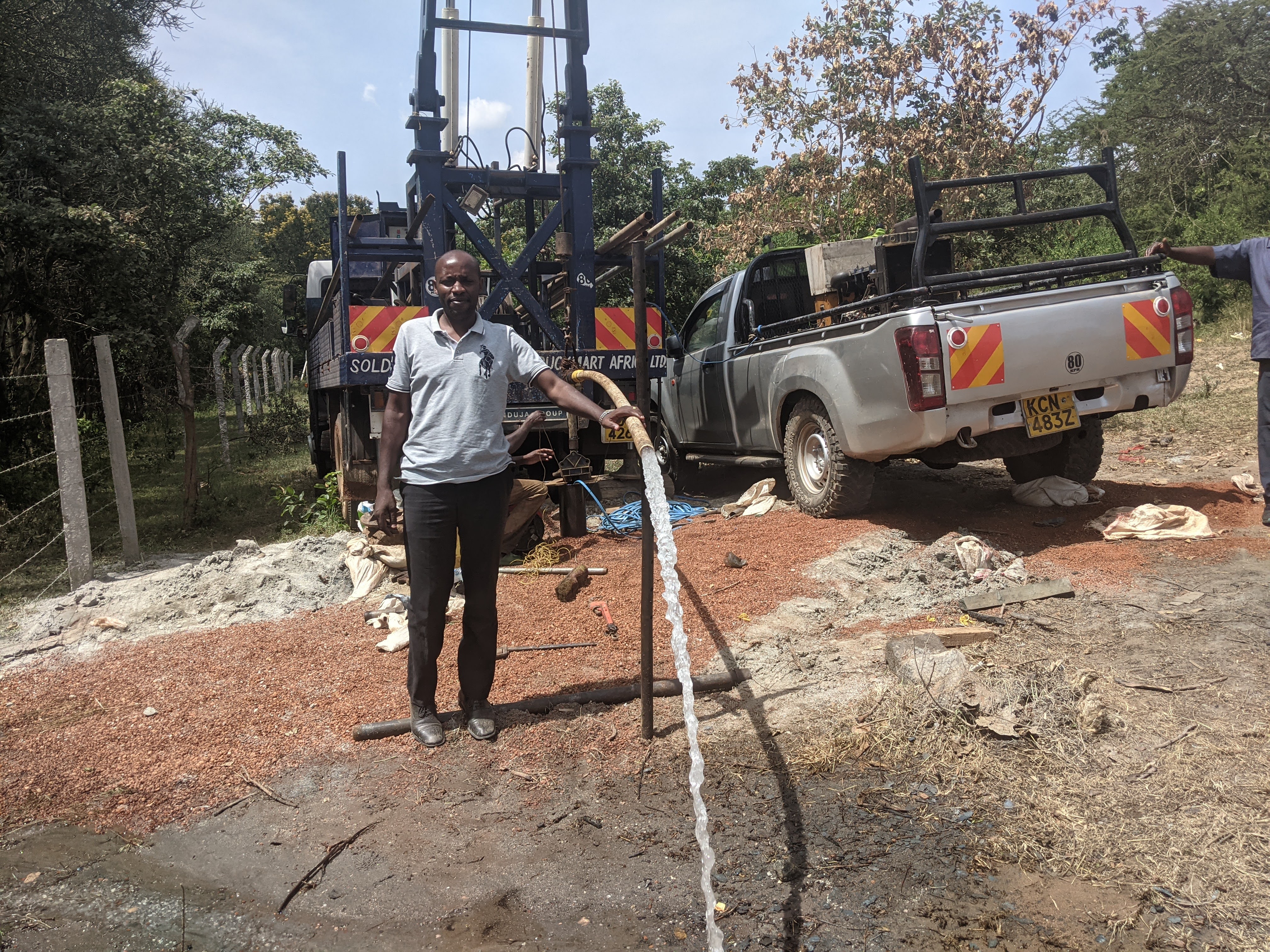 Completed borehole with pump and water flowing